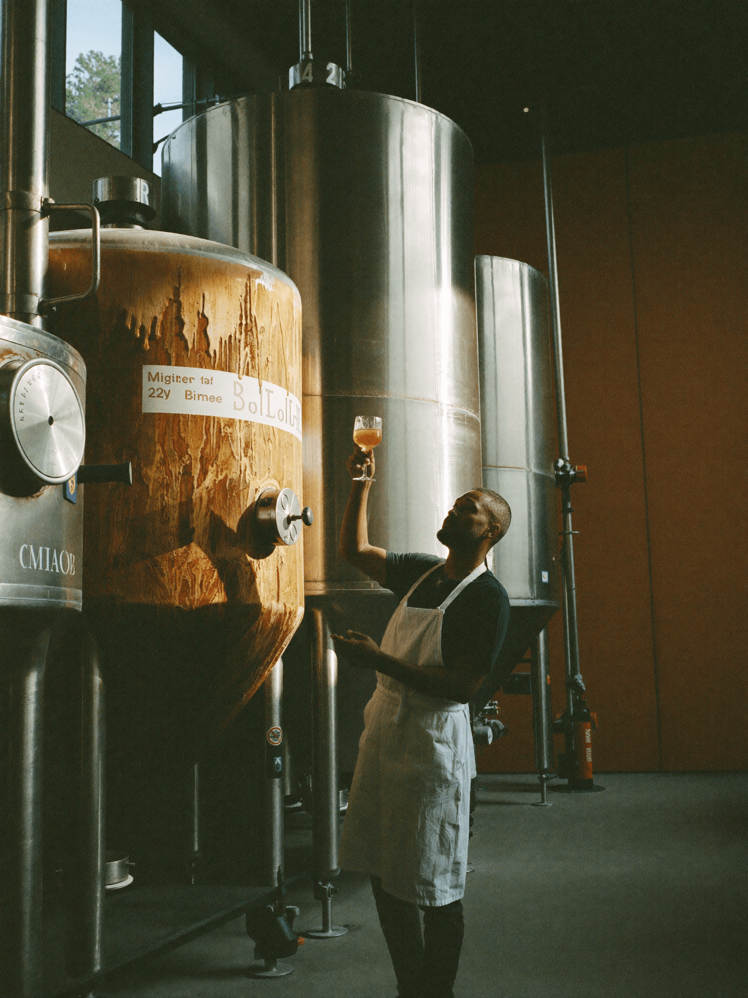 A Pombay distiller tasting at the fermentation tank in Amsterdam