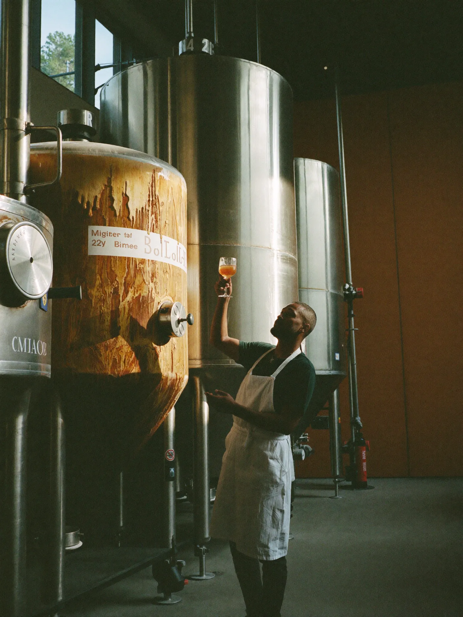 A Pombay distiller tasting at the fermentation tank in Amsterdam